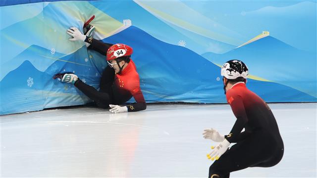 중국 쇼트트랙 대표팀 리원룽(왼쪽)이 11일 중국 베이징 수도체육관에서 열린 2022 베이징동계올림픽 쇼트트랙 남자 5000m 계주에서 넘어지고 있다. 베이징 뉴스1