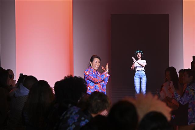 지난 2월 14일미국 뉴욕 패션위크 런웨이에서 인공지능(AI) 아티스트 틸다(오른쪽 화면)가 박윤희(왼쪽) 디자이너와 함께 관객들에게 인사하고 있다. LG그룹 제공