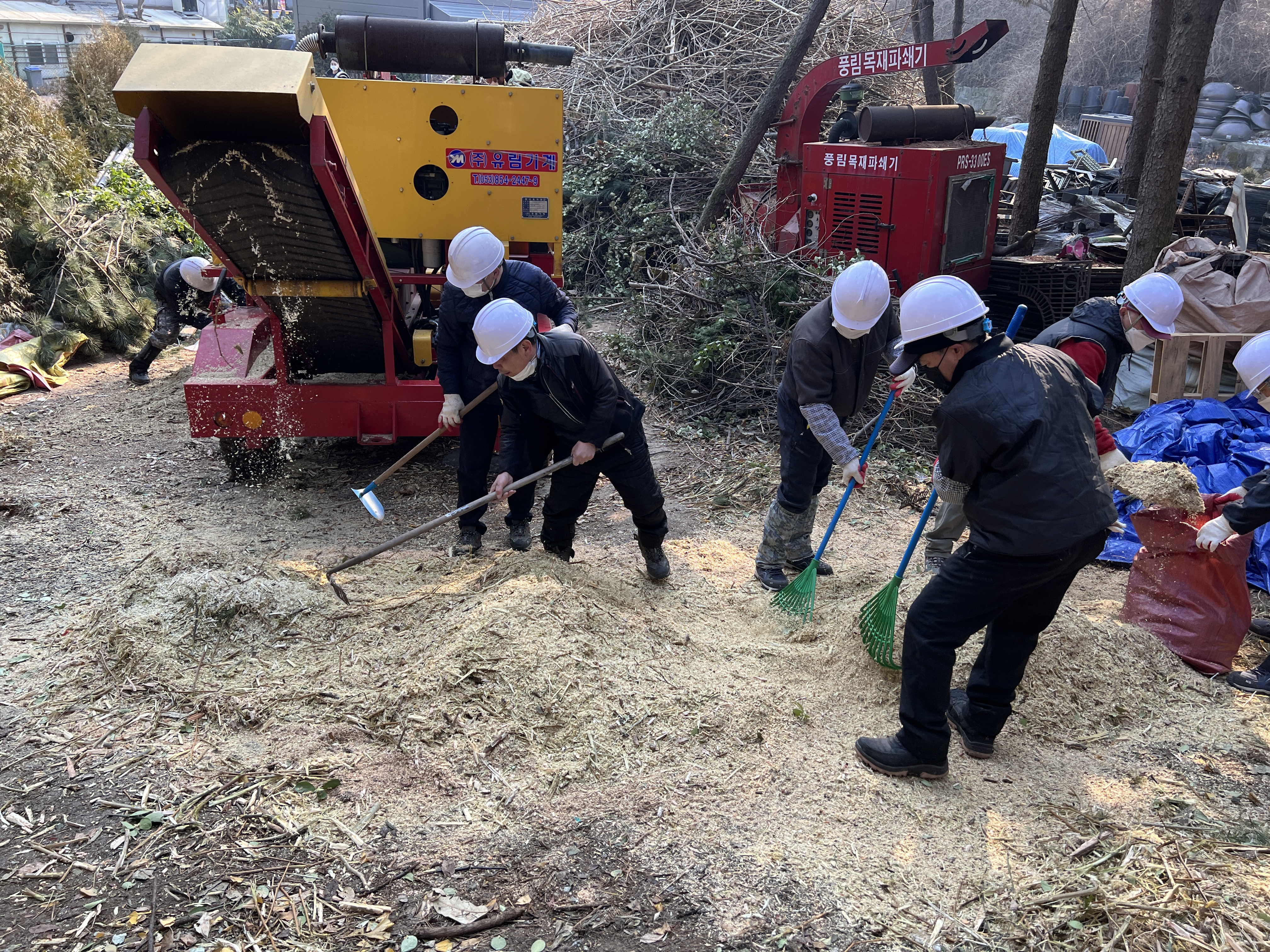 서울 강북구 관계자들이 공원 녹지 정비로 발생한 임목 부산물을 갈아 톱밥을 만들고 있다. 강북구 제공