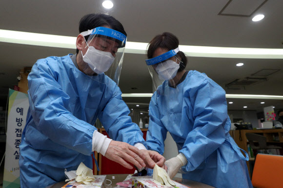 방역복 입는 안철수 후보와 김미경 교수