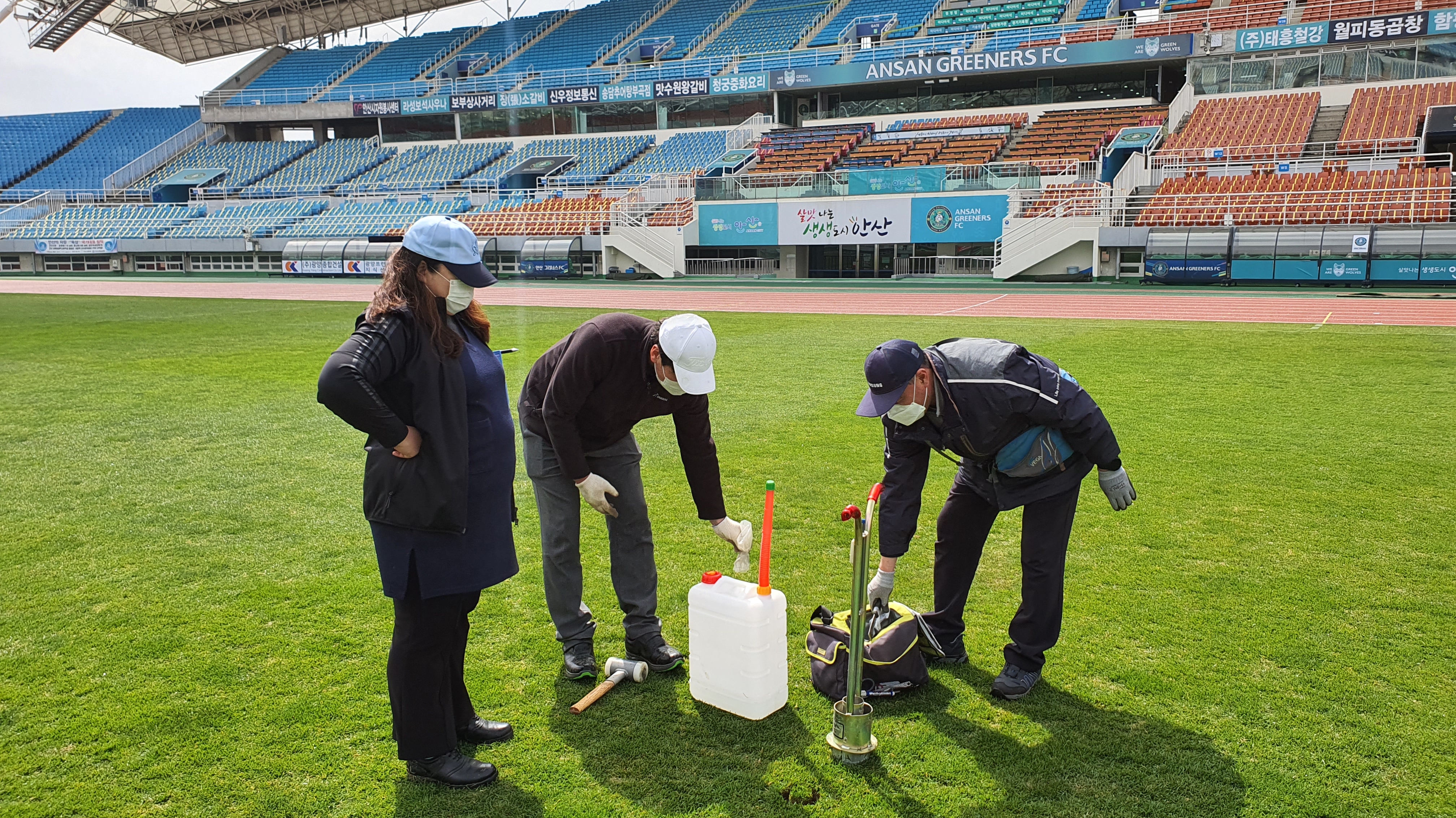 삼성물산 리조트부문 잔디환경연구소 직원들이 K리그 축구장의 잔디를 진단하고 있다. 삼성물산 제공.