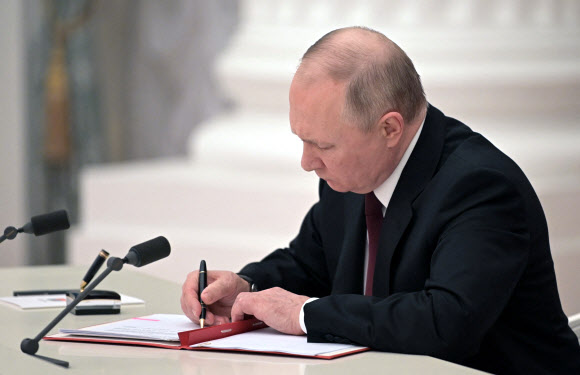 블라디미르 푸틴 러시아 대통령이 크렘린에서 DPR·LPR 독립 승인 내용의 대통령령에 서명하고 있다. 모스크바 AFP 연합뉴스