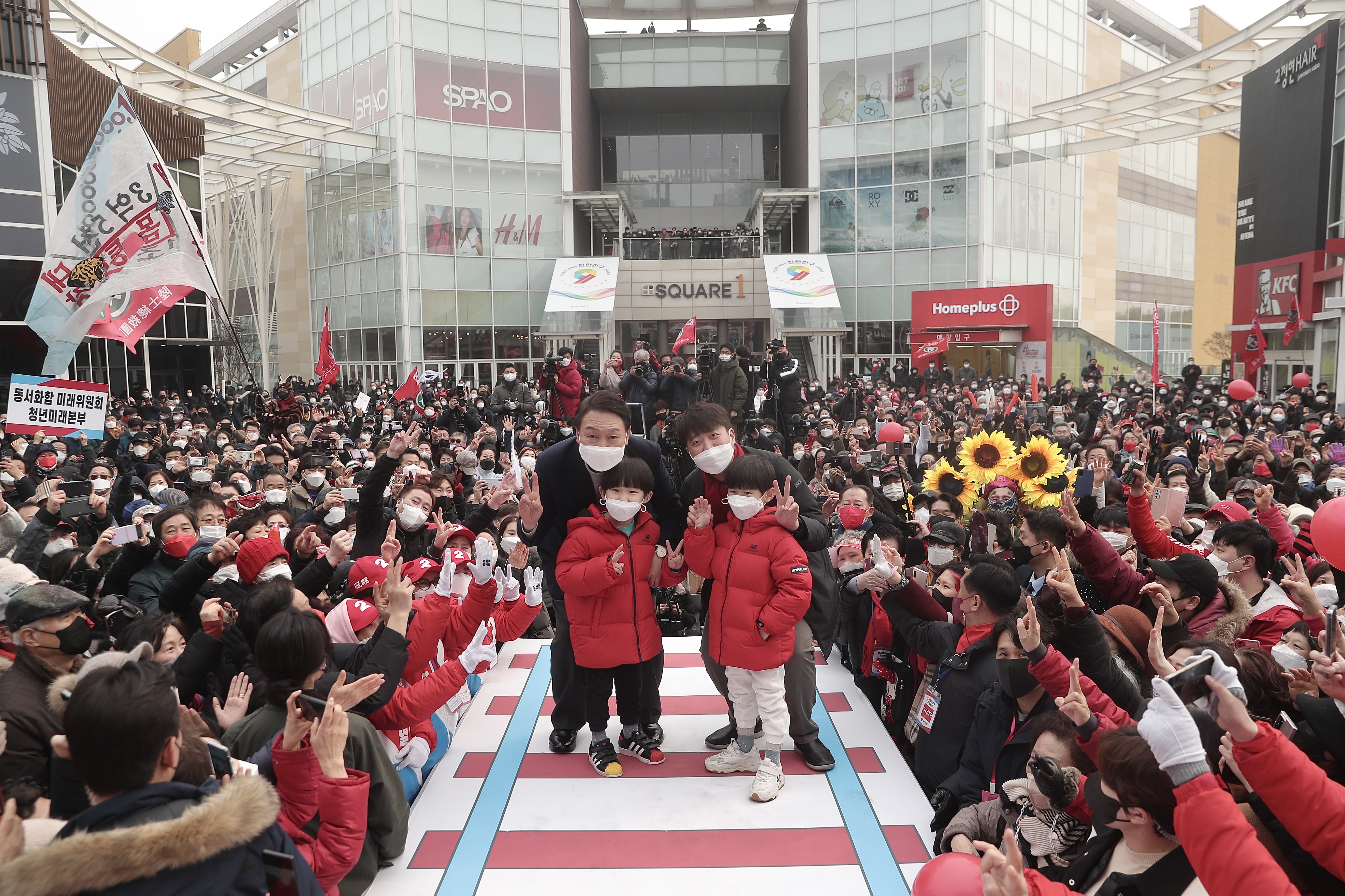 윤석열 국민의힘 대선후보와 이준석 대표가 26일 인천 연수구 스퀘어원에서 열린 유세에서 어린이들과 함께 사진 촬영을 하고 있다. 국민의힘 제공