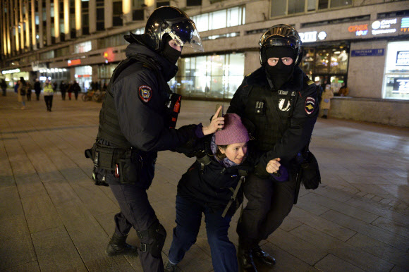 25일(현지시간) 러시아 모스크바에서 우크라이나 침공 반대 시위를 벌이던 여성이 경찰에게 연행되고 있다. 모스크바 AP 연합뉴스