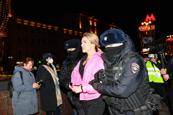 러시아 경찰들이 24일(현지시간) 모스크바에서 우크라이나 침공 반대 시위에 참가한 여성을 연행하고 있다. 모스크바 AFP 연합뉴스