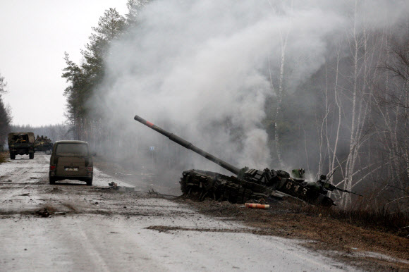 러시아의 우크라이나 침공 사흘째인 26일(현지시간) 우크라이나 동부 루한시크주에서 우크라이나군에 의해 파괴된 러시아 전차가 도로변에서 연기를 내뿜고 있다. 루한시크 AFP 연합뉴스