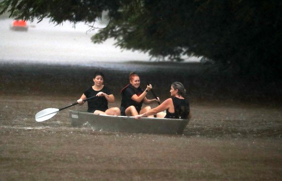 28일(현지시간) 호주 뉴사우스웨일스주 리스모어에 홍수가 발생하자 주민들이 소형 보트를 타고 침수 지역을 벗어나고 있다. EPA 연합뉴스