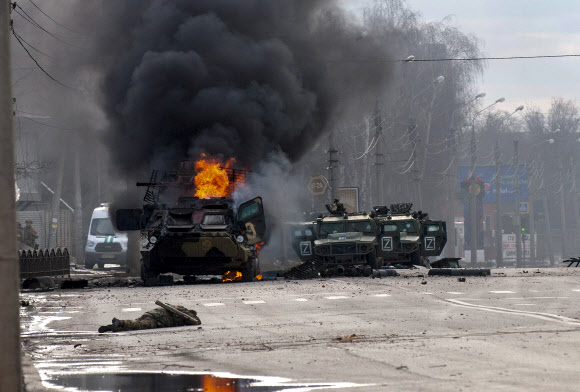 우크라이나가 러시아의 침공을 당한 지 나흘째인 27일(현지시간) 시가전이 벌어진 제2의 도시 하리코프의 거리에서 러시아군 병력수송용 장갑차 한 대가 불길에 휩싸여 있다. 2022.2.28  AFP 연합뉴스