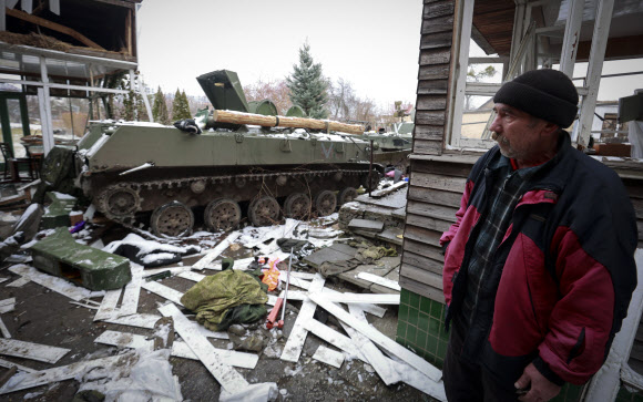 1일(현지시간) 우크라이나 수도 키이우(키예프) 외곽 부차에서 한 주민이 파괴된 러시아 군용 차량의 잔해를 바라보고 있다. 2022.3.2 AP 연합뉴스