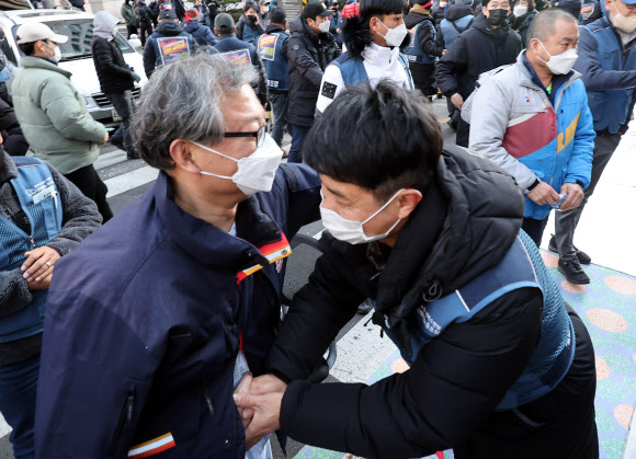 민주노총 전국택배노동조합(택배노조) 진경호 위원장(왼쪽)이 2일 오후 서울 중구 CJ대한통운 본사 앞에서 CJ대한통운 대리점연합 간 협상 결과 보고대회 종료 뒤 조합원과 악수하고 있다. 2022.3.2  연합뉴스