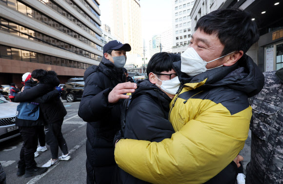 민주노총 전국택배노동조합(택배노조) 조합원들이 2일 오후 서울 중구 CJ대한통운 본사 앞에서 CJ대한통운 대리점연합 간 협상 결과 보고대회 종료 뒤 눈물을 흘리며 포옹하고 있다. 2022.3.2  연합뉴스