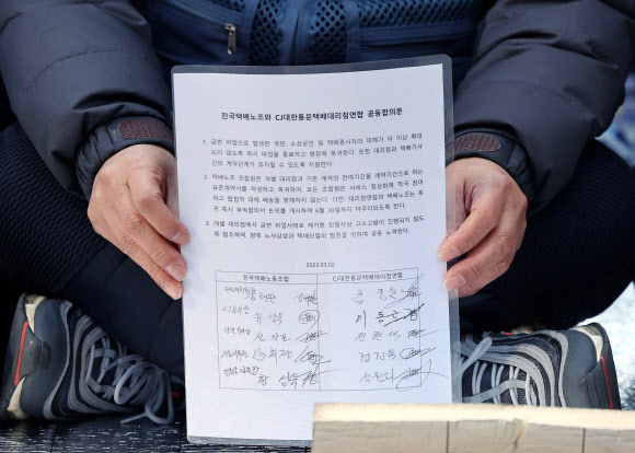 유성욱 택배노조 CJ대한통운 본부장이 2일 오후 서울 중구 CJ대한통운 본사 앞에서 파업 사태 관련 합의문을 들어 보이고 있다. 2022.3.2  연합뉴스