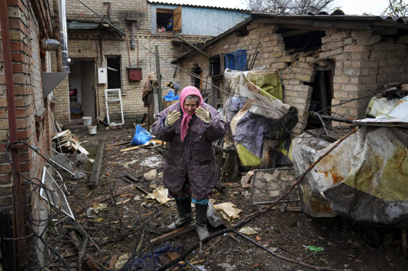 2일(현지시간) 우크라이나 수도 키이브 인근의 주택가에서 한 여성이 폭격 잔해 사이에서 슬퍼하고 있다. AP