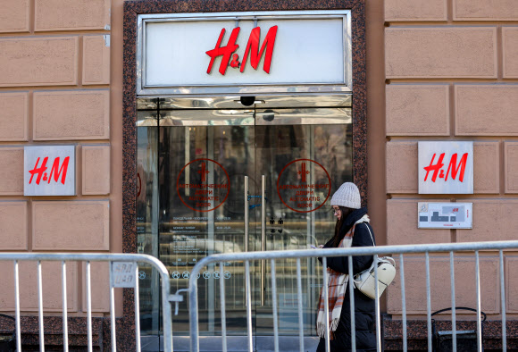 3일(현지시간) 러시아 모스크바에서 한 여성이 문이 닫힌 H&M 매장 앞을 지나고 있다. 글로벌 의류 브랜드 H&M은 러시아에서의 모든 판매를 일시 중지한다고 발혔다. 모스크바 로이터 연합뉴스
