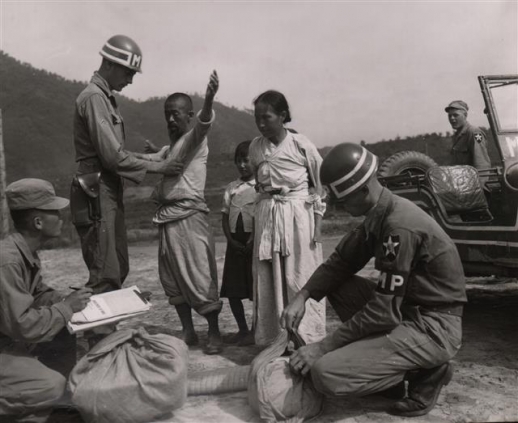 1951년 7월 피난민으로 보이는 민간인 가족이 포로수용소에 수용되기에 앞서 신체 수색을 받고 있는 모습(위 기사와 관련 없음). 대한민국역사박물관 제공
