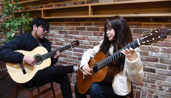 기타리스트 박규희(오른쪽)과 박주원이 서울 동작구 뮤직앤아트컴퍼니 스튜디오에서 호흡을 맞추며 연습하고 있다. 이들은 “손끝을 사용해야 하는 기타는 최고의 거장도 종종 실수할 정도로 예민한 악기”라고 말했다. 　안주영 전문기자
