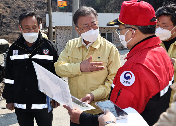강원ㆍ경북 산불현장 방문에 나선 문재인 대통령이 6일 경북 울진군 신화2리 화재현장을 방문해 최병암 산림청장 겸 통합지휘본부장으로부터 브리핑을 받고 있다. 2022. 3. 6  박지환 기자