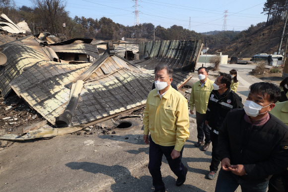 강원ㆍ경북 산불현장 방문에 나선 문재인 대통령이 6일 경북 울진군 신화2리 화재현장을 방문해 전호동 이장으로부터 보고를 받으며 마을을 둘러보고 있다. 2022. 3. 6  박지환 기자