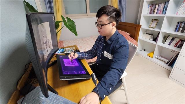 일러스트레이터 김도현씨가 경남 창원 자택에서 컴퓨터로 일러스트 작업을 하고 있다.
