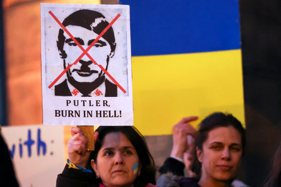지난 1일(현지시간) 영국 리버풀에서 열린 우크라이나 지지 시위에서 한 참가자가 블라디미르 푸틴 러시아 대통령을 아돌프 히틀러로 묘사한 포스터를 들고 있다. 리버풀 로이터 연합뉴스