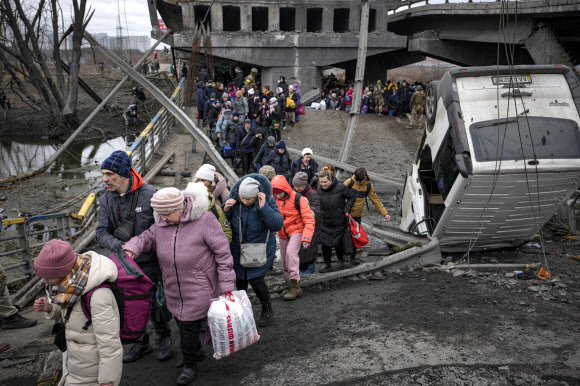 파괴된 다리 밑 임시통로 통해 피란하는 우크라 주민들