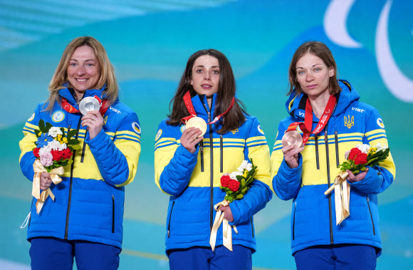 8일 중국 허베이성 장자커우에서 열린 바이애슬론 여자 중거리 입식에서 메달을 싹쓸이한 우크라이나 선수들이 메달 세리머니 행사에서 나란히 메달을 들고 기념촬영하는 모습. 장자커우 로이터 연합뉴스