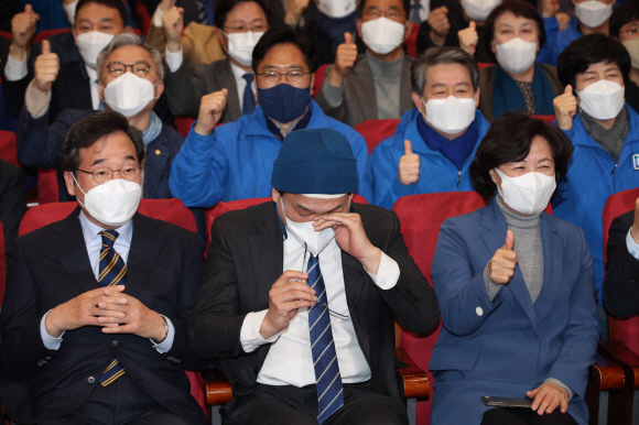 송영길 더불어민주당 대표가 제20대 대선 본투표일인 9일 서울 여의도 국회 의원회관 대회의실에 마련된 개표 상황실에서 지상파 방송 3사와 JTBC 출구조사 결과를 보며 눈물을 닦고 있다. 왼쪽부터 이낙연 총괄선대위원장, 송 대표, 추미애 명예선대위원장. 정연호 기자