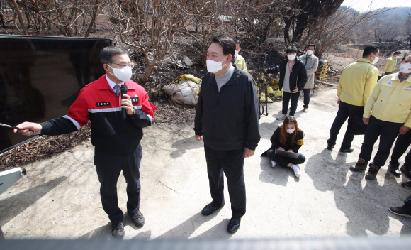 윤석열 대통령 당선인이 15일 경북 울진군 북면 검성리 산불피해 현장을 방문해 최병암 산림청장의 브리핑을 듣고 있다.2022. 3. 15  정연호 기자
