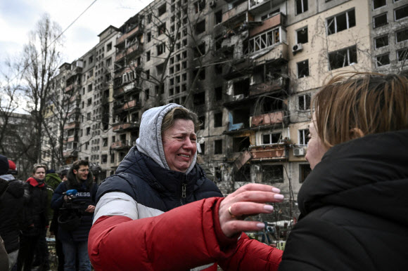 14일(현지시간) 러시아군의 포격으로 큰 피해를 본 우크라이나 수도 키이우 인근 오볼론 지구의 아파트 건물 주변에서 한 여성 주민이 슬퍼하고 있다. 당국은 이날 포격으로 2명이 숨졌다고 밝혔다. 2022.3.15 키이우 AFP 연합뉴스