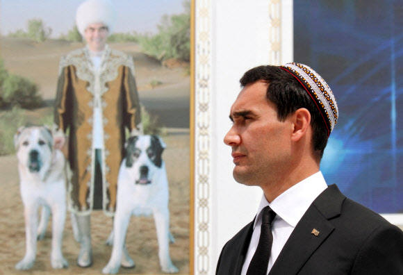 구르반굴리 베르디무하메도프 투르크메니스탄 대통령의 아들이자 부총리인 세르다르 베르디무하메도프가 말과 목양견의 날 축하행사에 참석하고 있다. 그의 뒤로 베르디무하메도프 대통령이 개들과 함께 서 있는 사진이 걸려 있다. 2021. 4. 25 아시가바트 로이터 연합뉴스