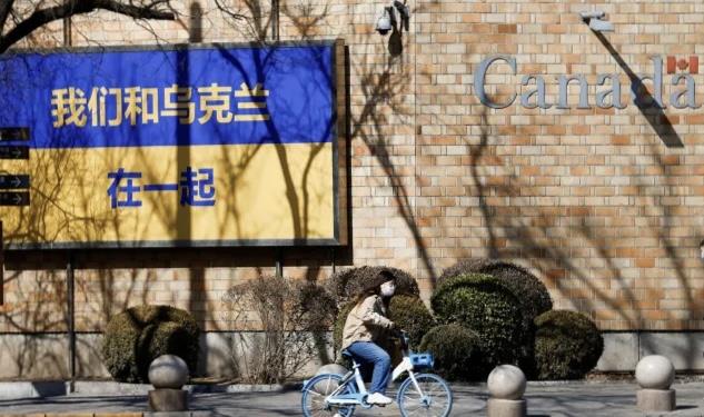 중국 베이징에서 한 시민이 자전거를 타고 우크라이나 지지 간판이 걸린 캐나다 대사관을 지나가고 있다. 베이징 로이터 연합뉴스