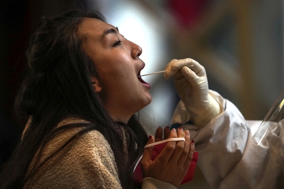 17일 중국 베이징 패럴림픽이 열리는 앤칭에서 행사에 참가한 한 여성이 코로나19 검사를 받고 있다. 베이징 AP 연합뉴스