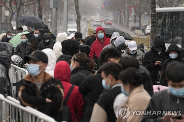 17일(현지시간) 중국 수도 베이징에서 눈이 내리는 가운데 시민들이 신종 코로나바이러스 감염증(코로나19) 검사를 받기 위해 줄을 서 있다. 2022.3.17 AP 연합뉴스