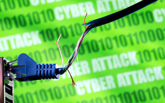 ‘사이버 공격’(cyber attack)이란 글자 앞에 끊어진 이더넷 케이블에 보이는 일러스트. 2022.3.8 로이터 연합뉴스