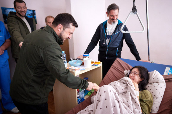 볼로디미르 젤렌스키 우크라이나 대통령이 17일(현지시간) 수도 키이우(키예프)의 한 병원을 방문해 피란 중 부상한 소녀를 위문하고 있다. 우크라 대통령실 제공·AFP 연합뉴스
