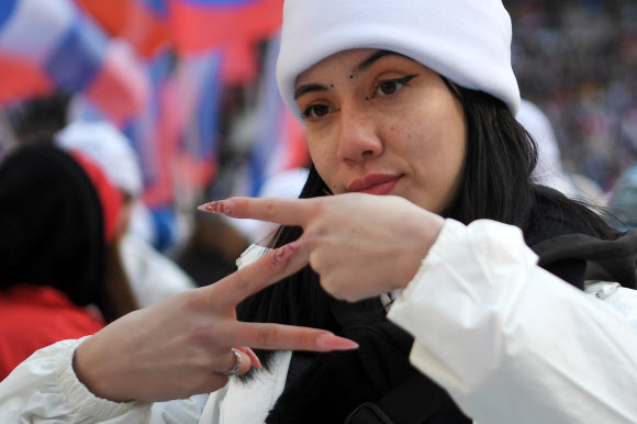 젊은 여성이 러시아군의 상징이 된 Z자를 만들어 보이고 있다. 2022.03.21 AP 연합뉴스