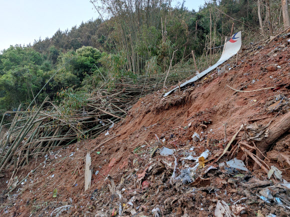 21일 중국 동방항공 소속 MU5735 여객기가 광시좡족자치구 우저우 텅현 인근 산악 지역에 추락한 가운데 추락 현장에서 비행기 잔해가 나뒹굴고 있다. 2022.3.22 로이터 연합뉴스