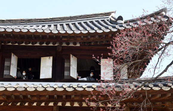 29일 서울 덕수궁에서 시민들이 석어당 2층에 올라 창문 너머로 살구꽃을 감상하고 있다. 덕수궁관리소는 덕수궁의 주요 전각 내부를 둘러보며 살구꽃을 감상할 수 있는 특별 공개 프로그램을 오는 3일까지 매일 2회(오전 10시, 오후 3시30분) 운영한다.2022.3.29  박윤슬 기자