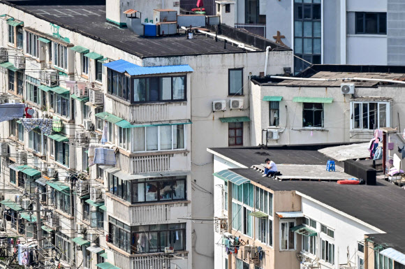 코로나19 확산을 막기 위한 중국 당국의 상하이 봉쇄가 열흘 넘게 이어지고 있는 가운데 상하이 징안구에서 한 주민 건물 옥상에 앉아 있다. 2022.4.6 AFP 연합뉴스