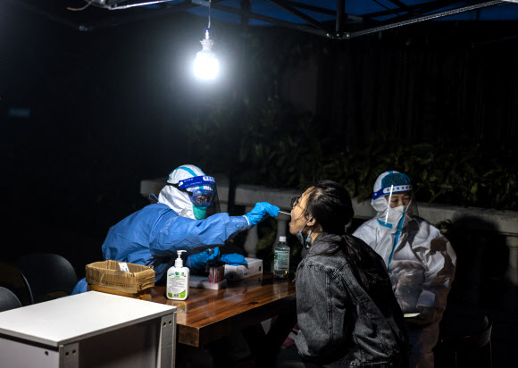 도시 봉쇄 13일째를 맞은 중국 상하이에서 한 여성이 코로나19 검사를 받고 있다. 2022.4.9 EPA 연합뉴스