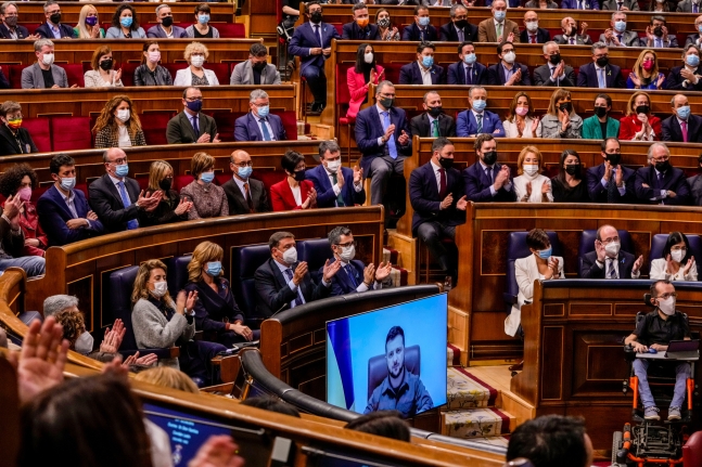 스페인 의원들이 5일(현지시각) 수도 마드리드 의사당에서 화상 연설에 나선 볼로디미르 젤렌스키(화면) 우크라이나 대통령에게 일제히 박수를 보내고 있다. AP 연합뉴스