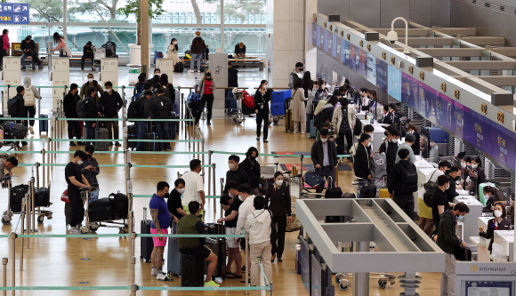 코로나19 영향으로 지난 2020년 3월 23일부터 전 국가·지역 대상으로 발령해온 특별여행주의보가 해제되고 각 국별 기존 여행경보 발령 체제로 전환된 14일 인천 중구 인천국제공항 1터미널 출국장에서 여행객들이 출국 수속을 하기 위해 줄지어 서 있다. 2022.4.14  오장환 기자