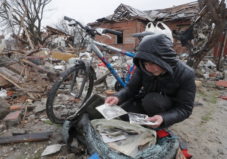 파괴된 잔해 더미 속에서 찾은 가족사진을 들여다보는 우크라 여성. 기사와 직접 관련 없음. EPA 연합뉴스 자료사진 