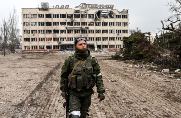 러시아군의 포격으로 파괴된 우크라이나 마리우폴의 아조우마쉬 연구·제조단지 앞을 한 병사가 걷고 있다. 2022.4.16 타스 연합뉴스