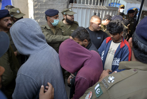 스리랑카인 집단 린치 살해 용의자들이 파키스탄 구지란왈라에서 경찰에 의해 호송되는 모습. 2021.12.6 AP 연합뉴스