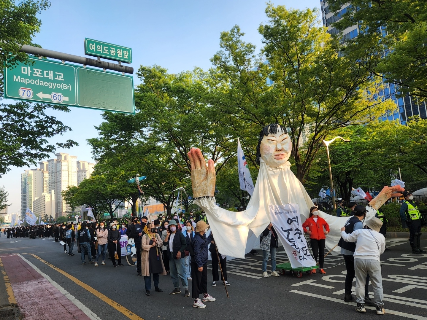 전국장애인차별철폐연대 등 장애인 단체들이 20일 여의도공원 앞 도로를 행진하며 장애인 차별 철폐를 상징하는 인형을 지탱하고 있다. 이날 여의도 이룸센터 앞에서 시작된 행진은 여의도역 2번 출구 앞에서 선회하는 경로로 진행됐다.<br>곽소영 기자
