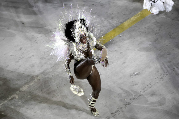22일(현지시간) 브라질 리우데자네이루 삼바드로무에서 열린 카니발 축하 퍼레이드에서 삼바 학교 무용단이 화려한 의상을 입고 춤을 추고 있다. AP 연합뉴스