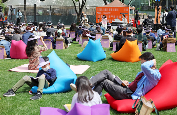 지난 4월 23일 서울광장에 설치된 야외도서관 ‘책 읽는 서울광장’에서 시민들이 잔디에 앉아 책을 읽으며 주말을 보내고 있다. 2022.4.23 연합뉴스