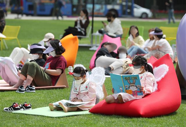 23일 서울광장에 설치된 야외도서관 ‘책 읽는 서울광장’에서 아이들이 잔디에 앉아 책을 읽고 있다. 책 읽는 서울광장은 탁 트인 서울광장을 서울도서관과 연계해 시민 누구나 자유롭게 책과 쉼, 문화를 누릴 수 있게 한 도심 속 열린 야외 도서관이다. 이번 행사는 이날부터 오는 10월말 까지 매주 금요일과 토요일 운영된다. 2022.4.23 뉴스1