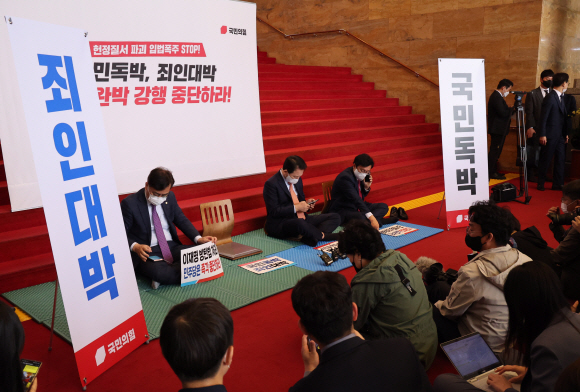 국민의힘 송언석 원내수석부대표(왼쪽부터)와 성일종 정책위의장 등 국민의힘 의원들이 27일 국회 본관 2층 계단에서 열린 ‘검수완박 강행처리 저지를 위한 연좌농성 선포식’을 마친 뒤 연좌농성에 돌입했다.2022. 4. 27  김명국 기자